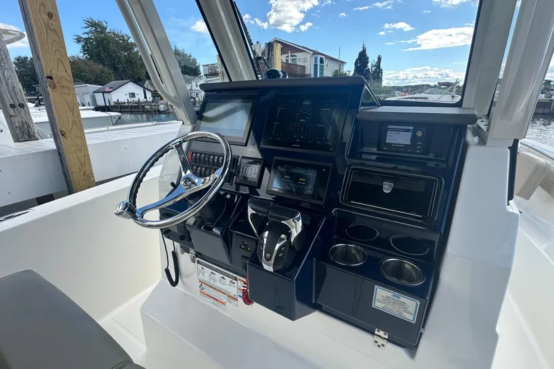 Slide: The Image of Helm of 2021 Pursuit S 288 Sport boat with modern controls and navigation displays. - 12