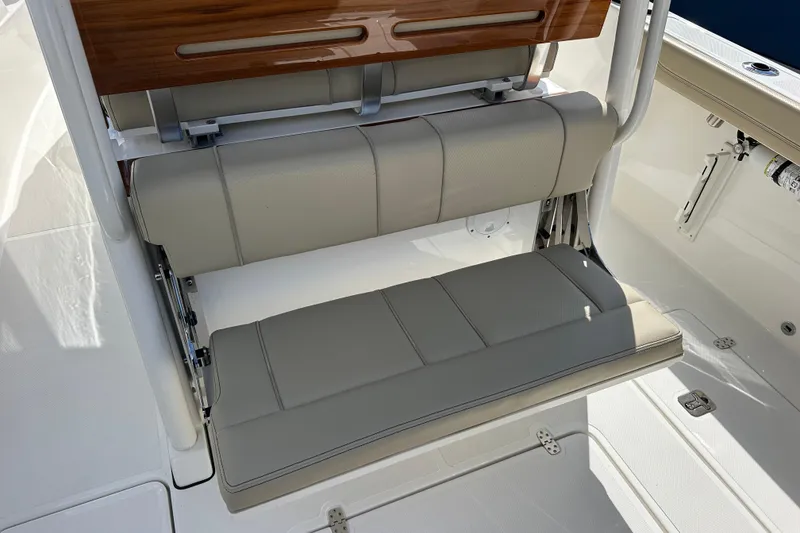 Slide: The Image of 2021 Pursuit S 288 Sport boat seat with beige cushions and wooden accents. - 16