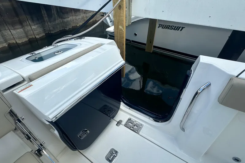 Slide: The Image of 2021 Pursuit S 288 Sport boat interior with open storage compartment and sleek design. - 19