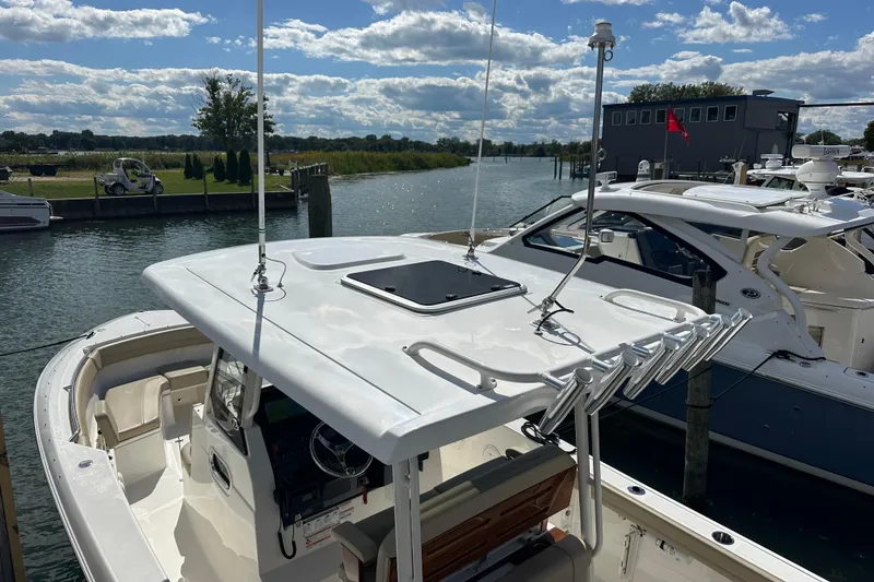 Slide: The Image of 2021 Pursuit S 288 Sport boat docked by a scenic waterfront. - 4