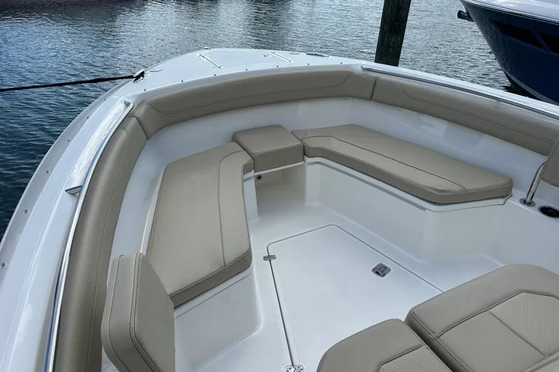 Slide: The Image of 2021 Pursuit S 288 Sport boat interior with beige seating, docked by water. - 5