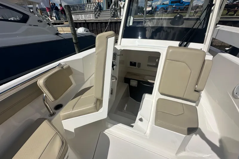 Slide: The Image of 2021 Pursuit S 288 Sport boat interior with beige seating and console. - 8