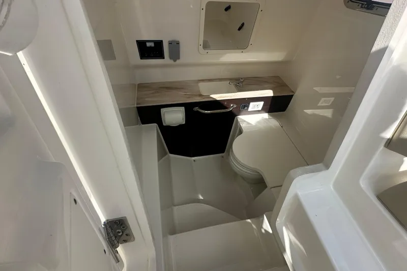 Slide: The Image of 2021 Pursuit S 288 Sport boat interior with compact bathroom and modern fixtures. - 9