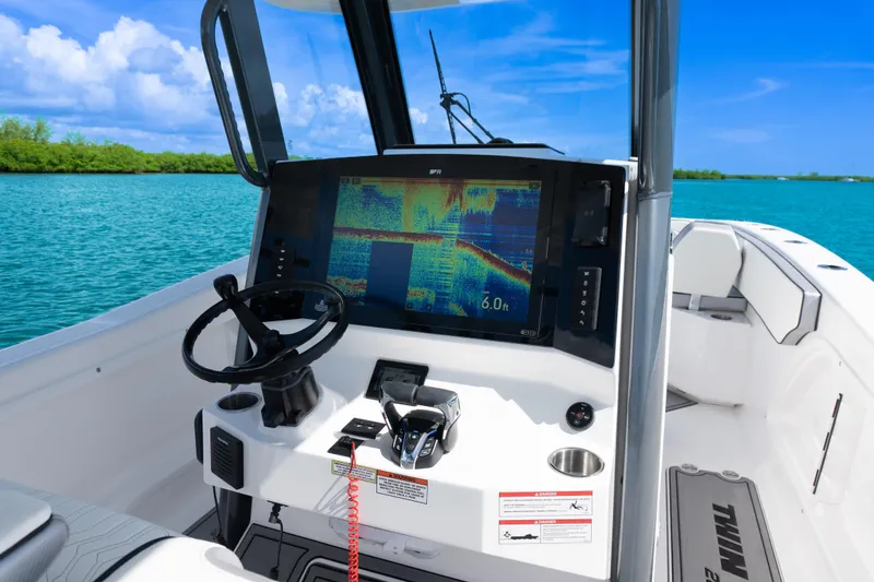 Slide: The Image of 2025 Twin Vee 260 GFX2 CC boat dashboard with navigation display on serene blue water. - 12