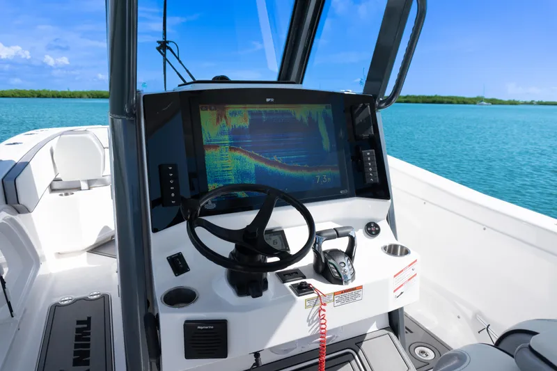 Slide: The Image of 2025 Twin Vee 260 GFX2 CC boat dashboard with advanced navigation system on open water. - 13