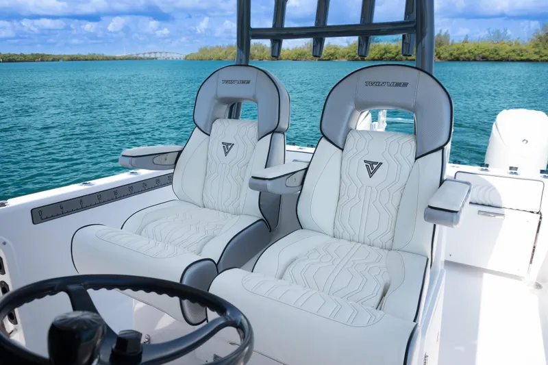 Slide: The Image of 2025 Twin Vee 260 GFX2 CC boat interior with luxurious seating on a serene water backdrop. - 18
