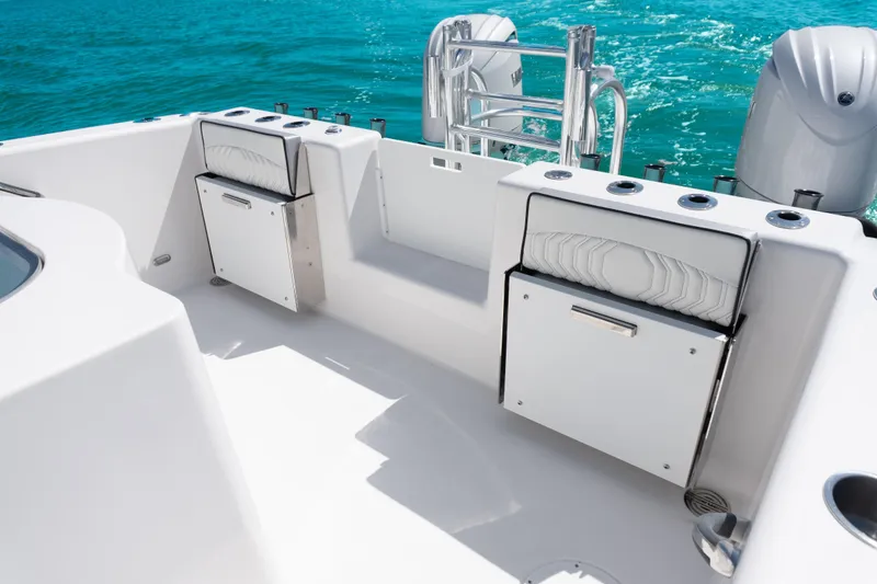 Slide: The Image of 2025 Twin Vee 260 GFX2 CC boat interior with seating and storage, on clear blue water. - 19