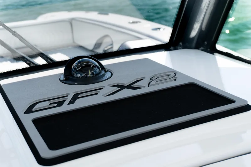 Slide: The Image of 2025 Twin Vee 260 GFX2 CC boat dashboard with compass, sleek design. - 34