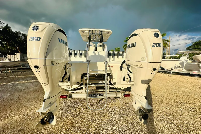 Slide: The Image of 2025 Twin Vee 260 GFX2 CC boat with dual Yamaha 200 engines, parked outdoors. - 4