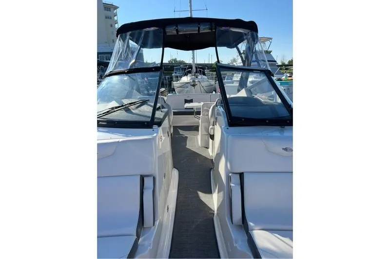 Slide: The Image of 2016 Chaparral 307 SSX boat with black canopy, docked in marina. - 10