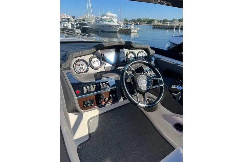 Slide: The Image of 2016 Chaparral 307 SSX boat dashboard with steering wheel and control panel at marina. - 11
