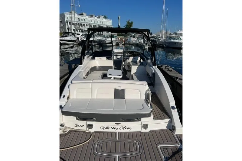 Slide: The Image of 2016 Chaparral 307 SSX boat docked at marina, featuring spacious seating and sleek design. - 25