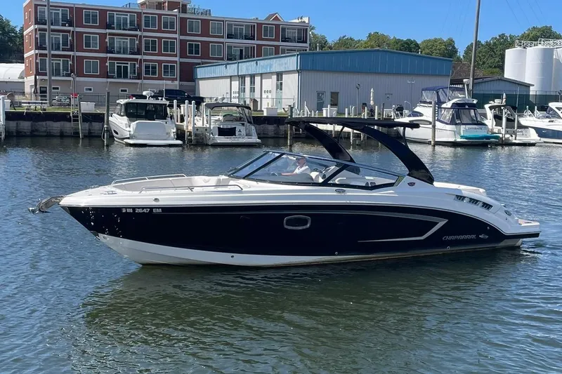 Slide: The Image of 2016 Chaparral 307 SSX boat docked in marina, surrounded by other vessels. - 26