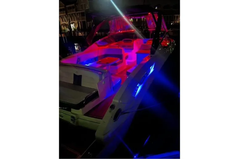 Slide: The Image of 2016 Chaparral 307 SSX boat with vibrant red and blue interior lighting at night. - 5