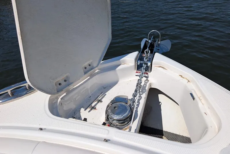 Slide: The Image of Open anchor compartment on 2016 Chaparral 307 SSX boat, showing chain and winch. - 9