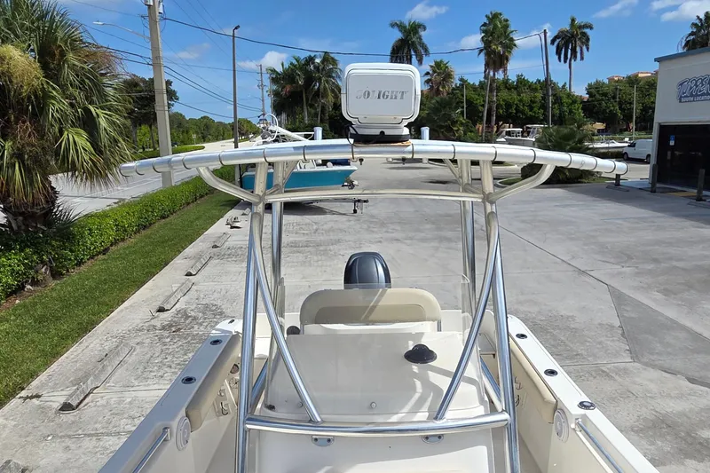 Slide: The Image of 2014 Cobia 217 Center Console boat with T-top, parked on a sunny day. - 11