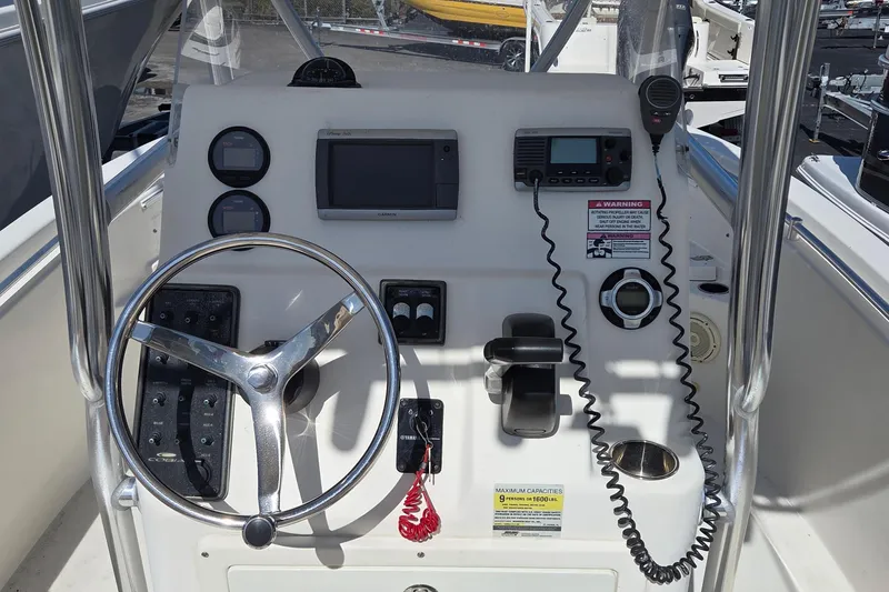 Slide: The Image of 2014 Cobia 217 Center Console boat dashboard with steering wheel and navigation controls. - 14