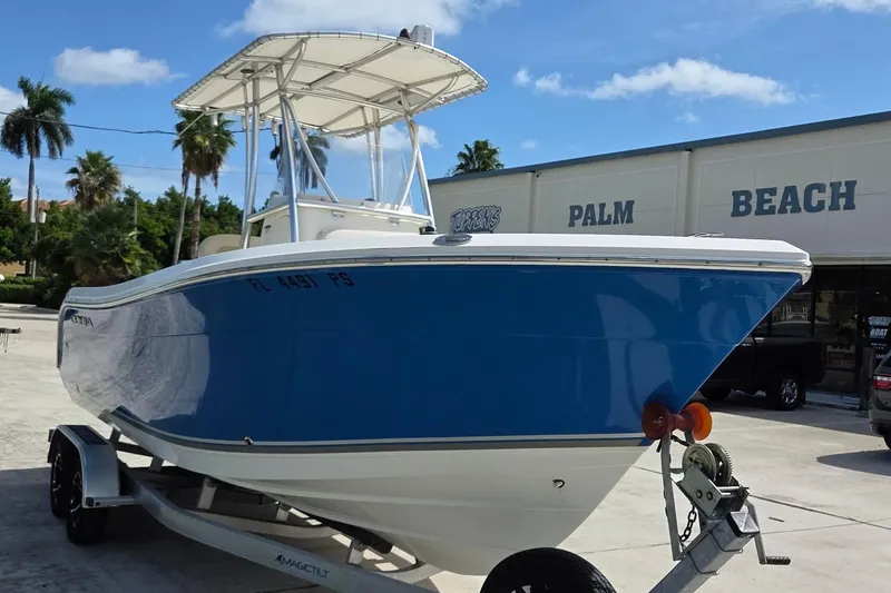 Slide: The Image of 2014 Cobia 217 Center Console boat on trailer, blue hull, Palm Beach location. - 2