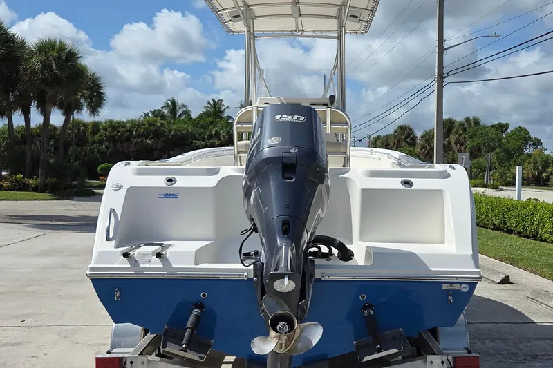 Slide: The Image of 2014 Cobia 217 Center Console boat with Yamaha 150 outboard motor, parked outdoors. - 3