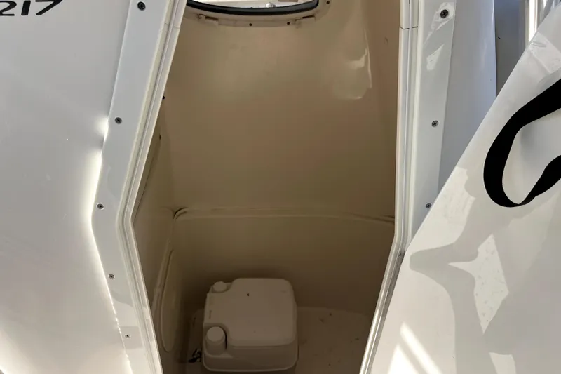 Slide: The Image of 2014 Cobia 217 Center Console boat interior with compact toilet. - 5