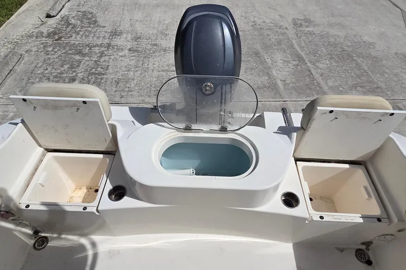 Slide: The Image of 2014 Cobia 217 Center Console boat with storage compartments and motor, viewed from above. - 7