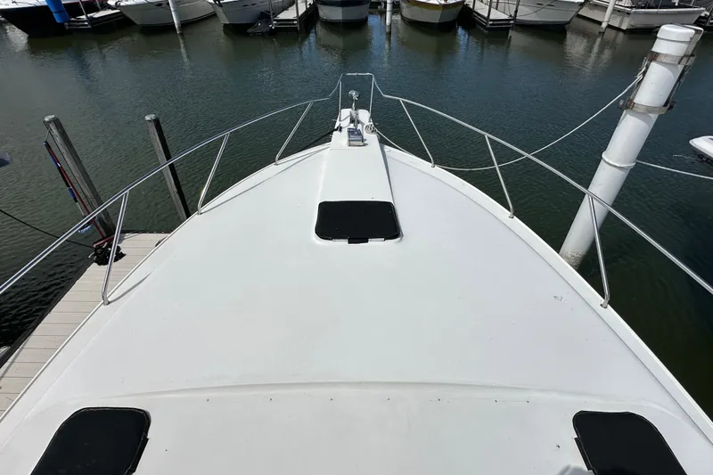 Slide: The Image of 1990 Silverton 34 Express boat docked at marina, view from bow. - 10
