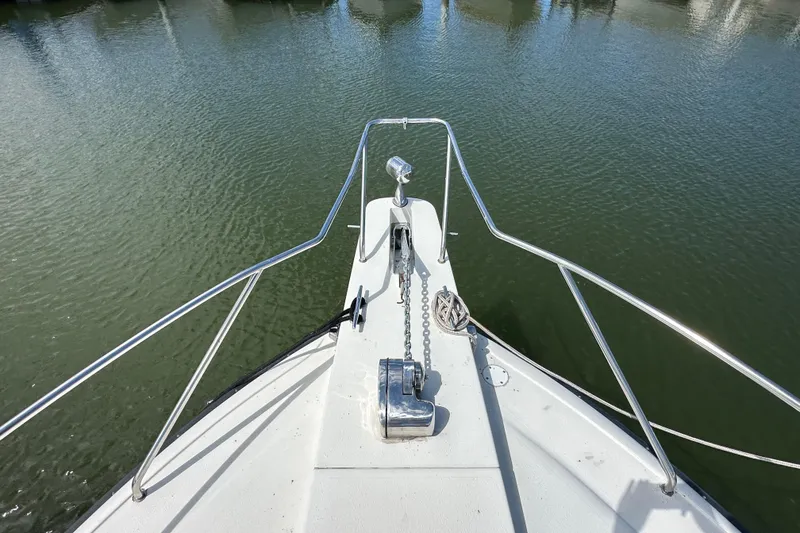 Slide: The Image of Bow view of 1990 Silverton 34 Express boat on calm water. - 11