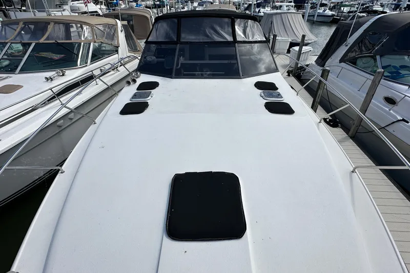 Slide: The Image of 1990 Silverton 34 Express yacht docked at marina, showcasing sleek deck design. - 12