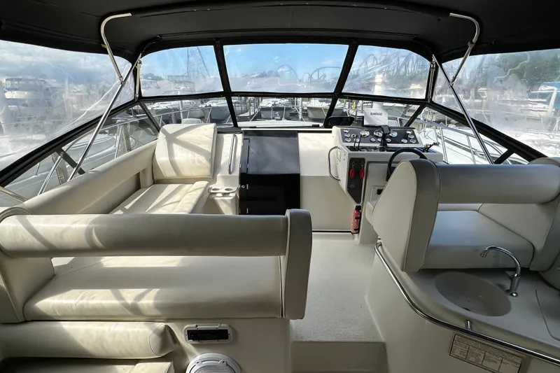 Slide: The Image of 1990 Silverton 34 Express yacht interior with helm, seating, and panoramic windows. - 13