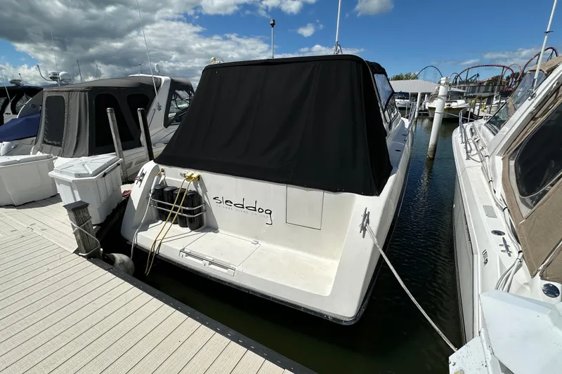Slide: The Image of 1990 Silverton 34 Express boat docked at marina under cloudy sky. - 2