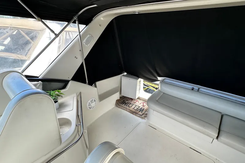 Slide: The Image of 1990 Silverton 34 Express boat interior with seating, black curtains, and welcome mat. - 20