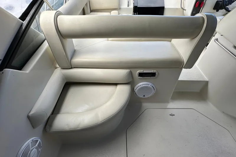 Slide: The Image of 1990 Silverton 34 Express boat interior seating with white upholstery and speaker system. - 21