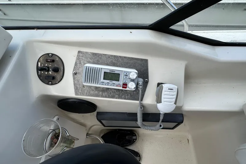 Slide: The Image of 1990 Silverton 34 Express boat dashboard with Uniden marine radio and controls. - 27