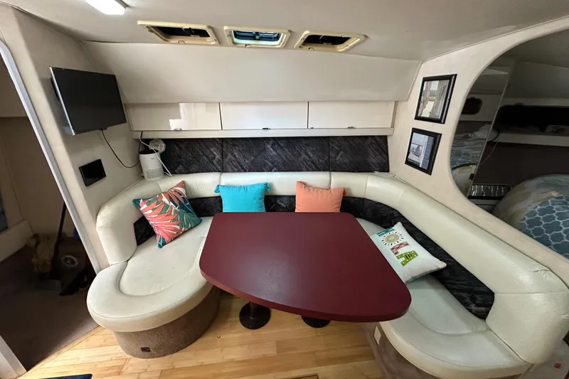 Slide: The Image of 1990 Silverton 34 Express interior with cozy seating, colorful cushions, and a mounted TV. - 28