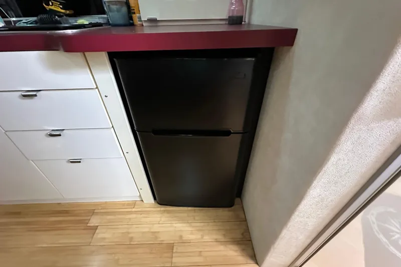 Slide: The Image of Compact black refrigerator in a 1990 Silverton 34 Express boat kitchen. - 32