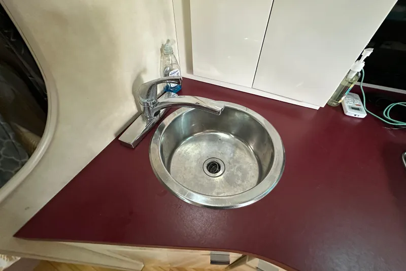 Slide: The Image of 1990 Silverton 34 Express boat interior sink with maroon countertop and chrome faucet. - 33