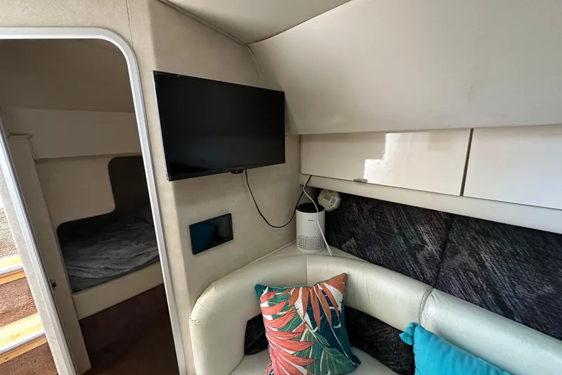 Slide: The Image of 1990 Silverton 34 Express cabin interior with TV, seating, and colorful pillows. - 35
