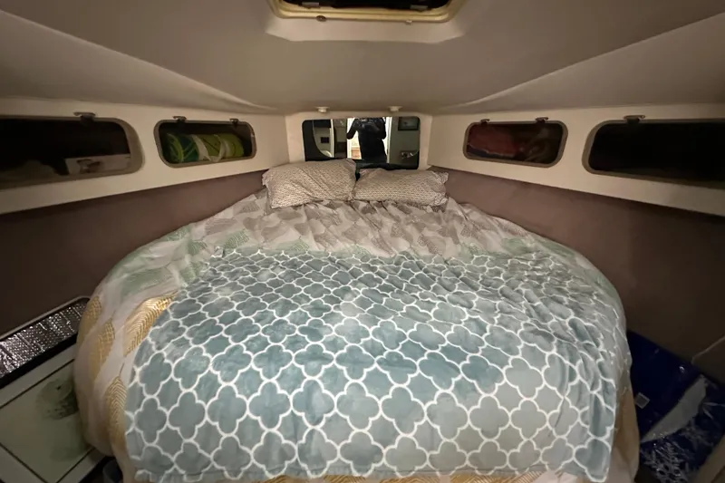 Slide: The Image of Cozy cabin bedroom in a 1990 Silverton 34 Express boat with patterned bedding. - 37