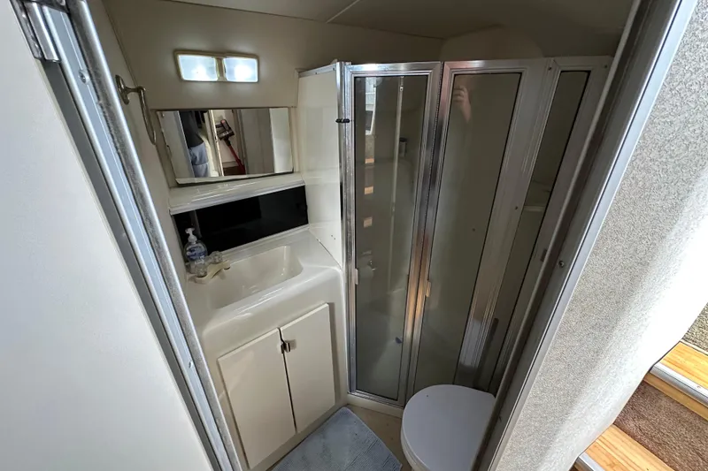 Slide: The Image of 1990 Silverton 34 Express yacht bathroom with shower, sink, and toilet. - 41