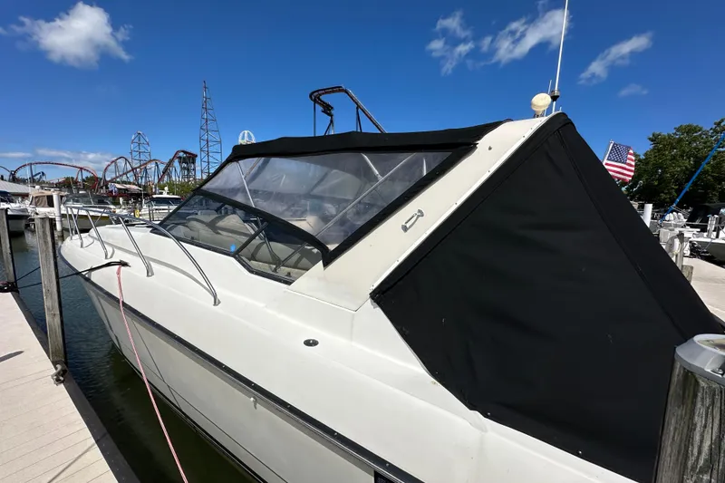 Slide: The Image of 1990 Silverton 34 Express boat docked, featuring black canopy and clear skies. - 5