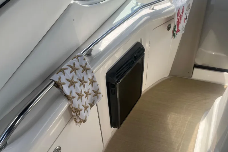 Slide: The Image of Interior of 2007 Sea Ray 300 Sundancer with starfish-patterned towel and compact fridge. - 14