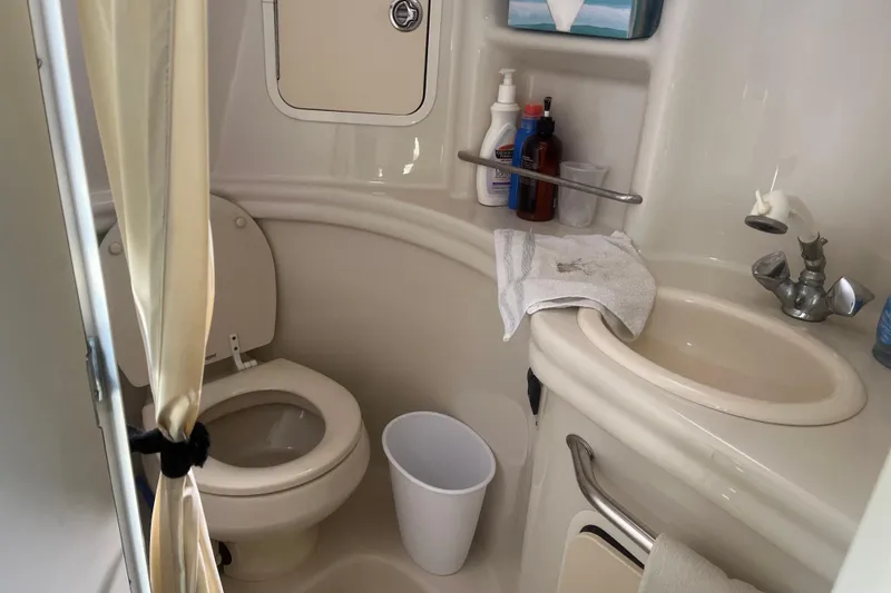 Slide: The Image of 2007 Sea Ray 300 Sundancer bathroom with toilet, sink, and toiletries. - 19