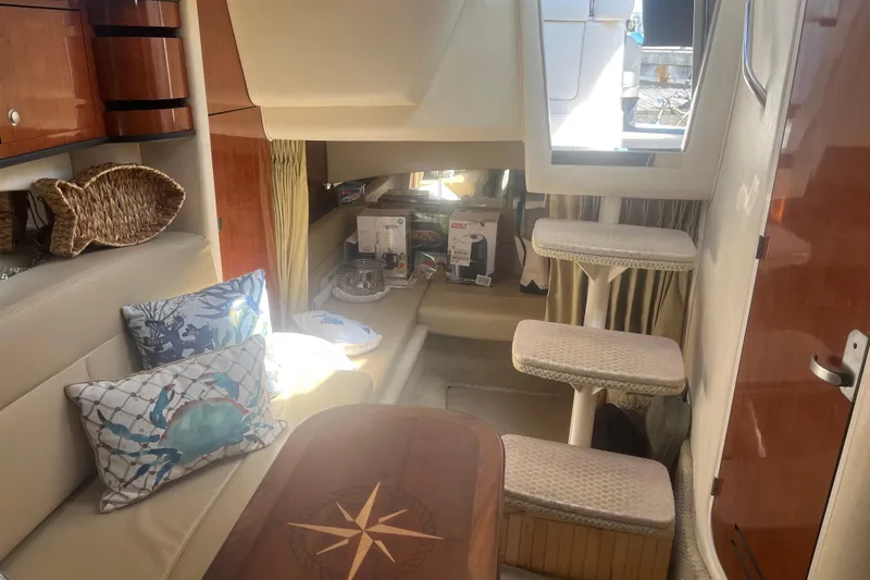 Slide: The Image of Interior of 2007 Sea Ray 300 Sundancer with cozy seating and nautical decor. - 21