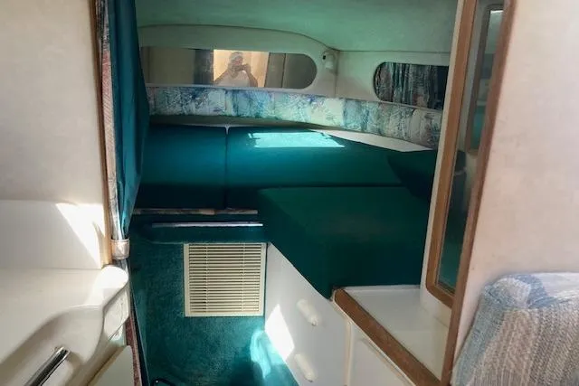Slide: The Image of 1994 Sea Ray 290 Sundancer cabin interior with teal upholstery and compact design. - 4