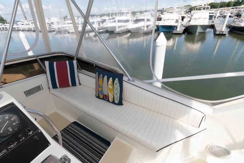 Slide: The Image of 1990 Viking 50 Motor Yacht interior with striped cushions, marina view, and nautical decor. - 12