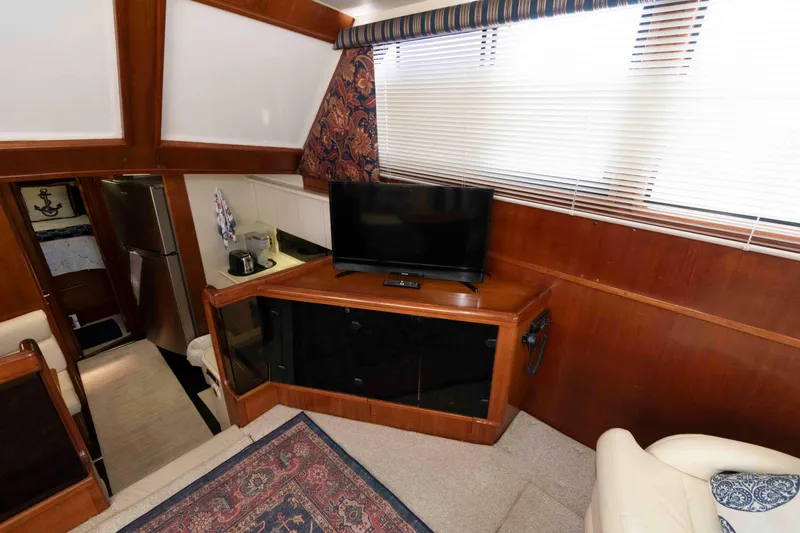 Slide: The Image of Interior of 1990 Viking 50 Motor Yacht with TV, wooden cabinetry, and modern appliances. - 21