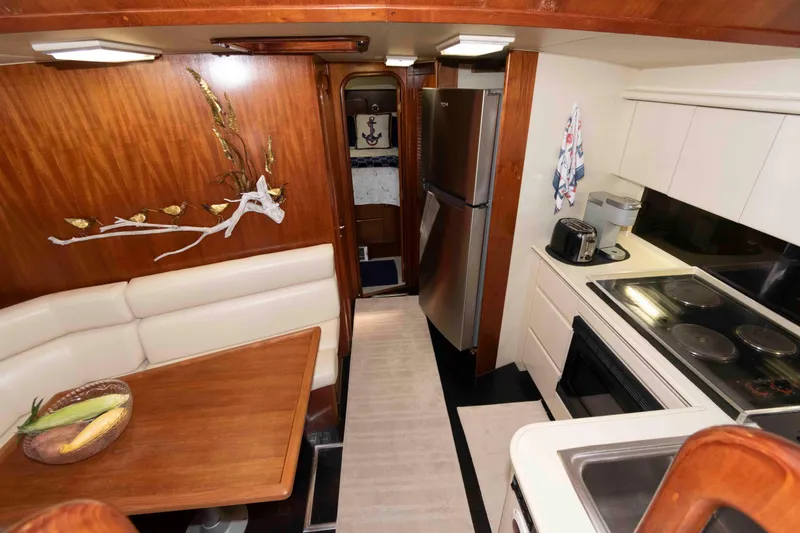 Slide: The Image of Interior of 1990 Viking 50 Motor Yacht with kitchen and dining area. - 22