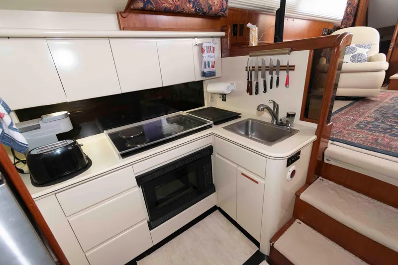 Slide: The Image of Compact kitchen in a 1990 Viking 50 Motor Yacht with modern appliances and storage. - 23