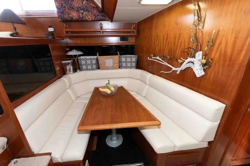 Slide: The Image of Interior of 1990 Viking 50 Motor Yacht with elegant dining area and wooden accents. - 24