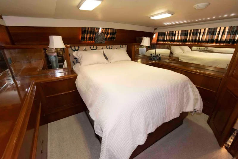 Slide: The Image of Luxurious bedroom interior of 1990 Viking 50 Motor Yacht with wood accents and cozy bedding. - 25